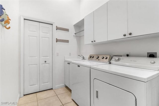 laundry room with a sink, cabinet space, independent washer and dryer, and light tile patterned floors