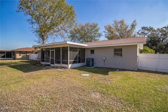 back of property featuring cooling unit, a lawn, and a sunroom