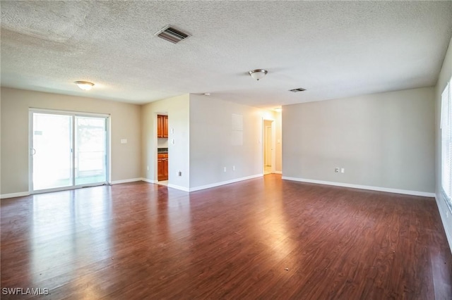 unfurnished room featuring dark hardwood / wood-style floors and a textured ceiling