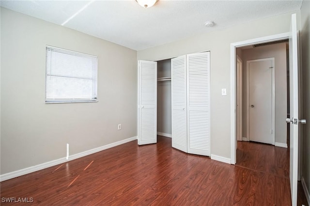 unfurnished bedroom featuring dark wood-type flooring and a closet