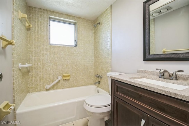 full bathroom featuring tiled shower / bath, vanity, toilet, and a textured ceiling