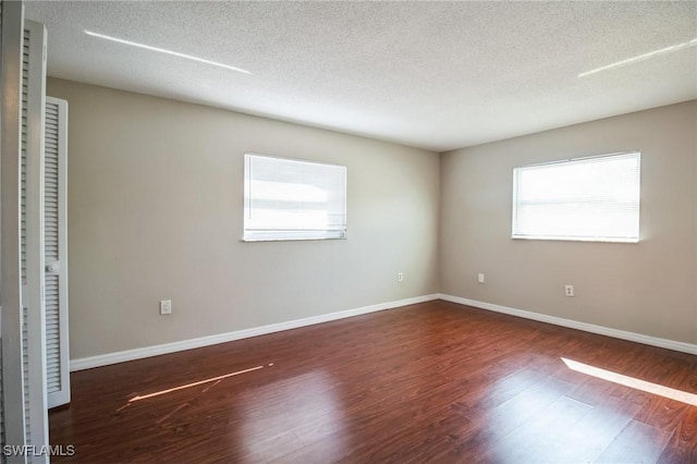 unfurnished bedroom featuring dark hardwood / wood-style floors and a textured ceiling