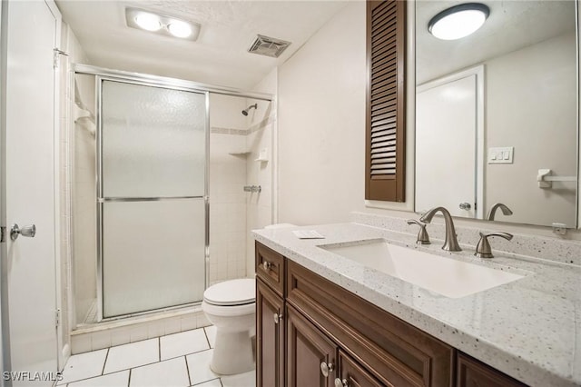 bathroom with vanity, toilet, an enclosed shower, and tile patterned flooring