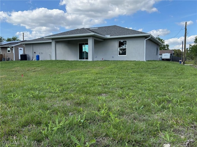 back of house with a yard and central AC unit