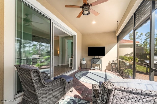 sunroom / solarium featuring ceiling fan