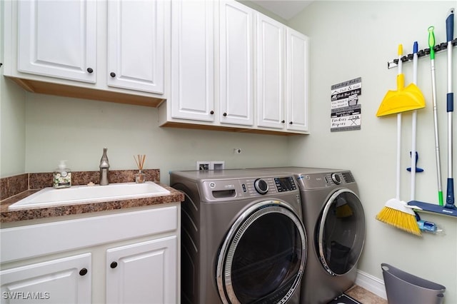 laundry area featuring separate washer and dryer, sink, and cabinets