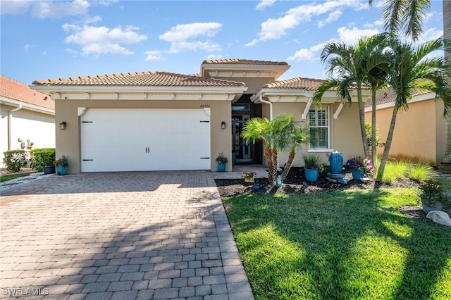 mediterranean / spanish house featuring a garage and a front yard