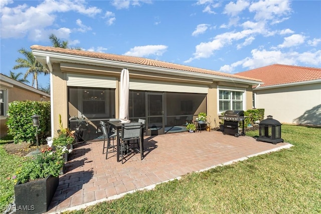 back of property featuring a sunroom, a lawn, and a patio area