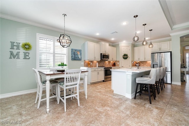 kitchen with stainless steel appliances, pendant lighting, a center island with sink, and decorative backsplash