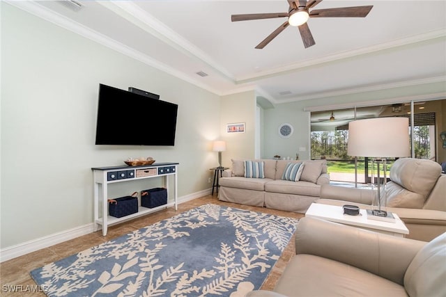 living room with tile patterned flooring, ornamental molding, ceiling fan, and a tray ceiling