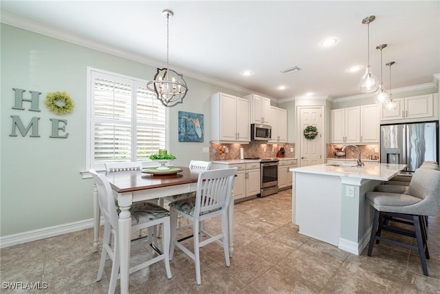 kitchen with stainless steel appliances, an island with sink, tasteful backsplash, and pendant lighting