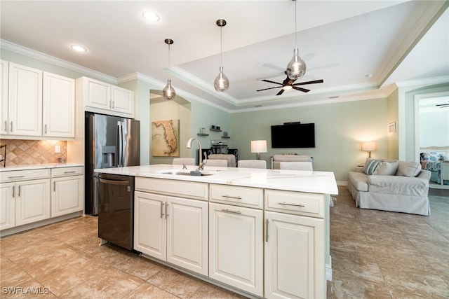 kitchen featuring white cabinetry, decorative light fixtures, a center island with sink, a tray ceiling, and dishwasher