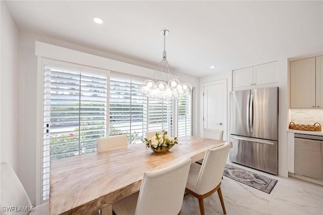 dining space featuring marble finish floor, recessed lighting, and a notable chandelier