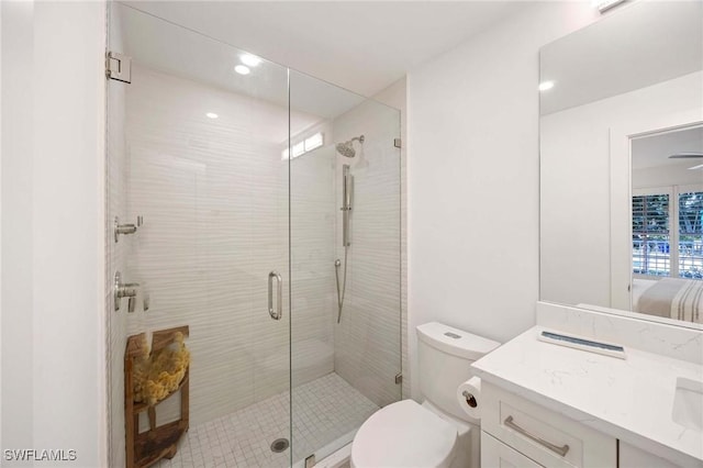 full bath featuring a stall shower, vanity, toilet, and recessed lighting