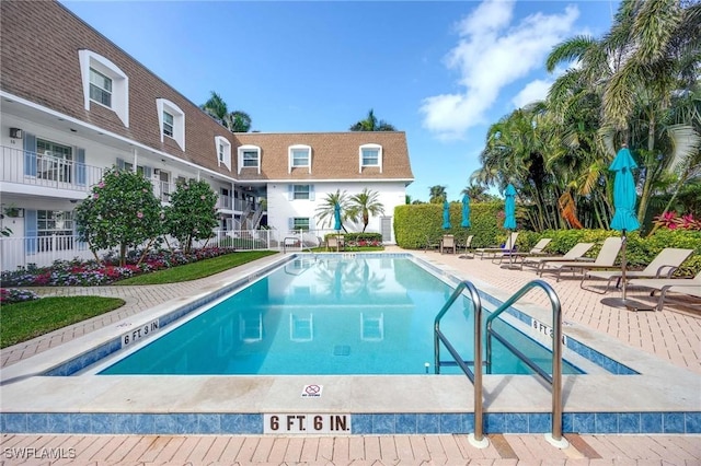 community pool featuring a patio area and fence