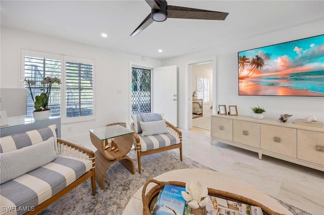 living area with marble finish floor, plenty of natural light, a ceiling fan, and recessed lighting