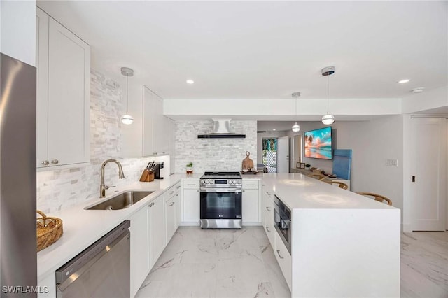 kitchen with marble finish floor, stainless steel appliances, a sink, a peninsula, and wall chimney exhaust hood