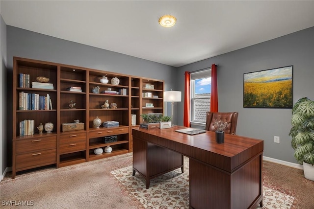 home office with baseboards and light colored carpet