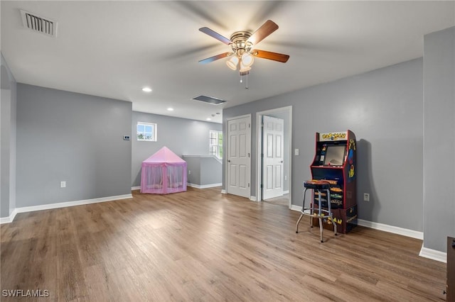 recreation room featuring baseboards, visible vents, and wood finished floors