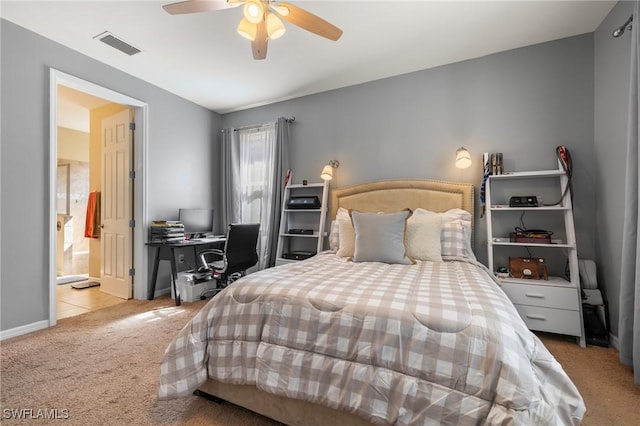 carpeted bedroom featuring a ceiling fan, ensuite bath, visible vents, and baseboards