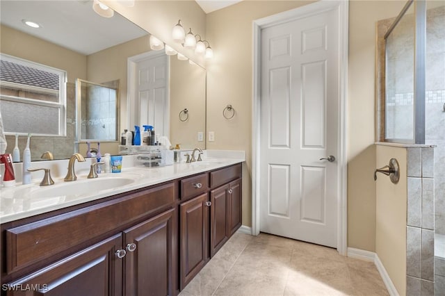 full bath with double vanity, tile patterned floors, a sink, and tiled shower