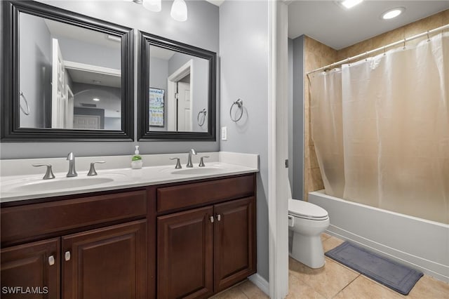 bathroom featuring double vanity, toilet, a sink, and tile patterned floors