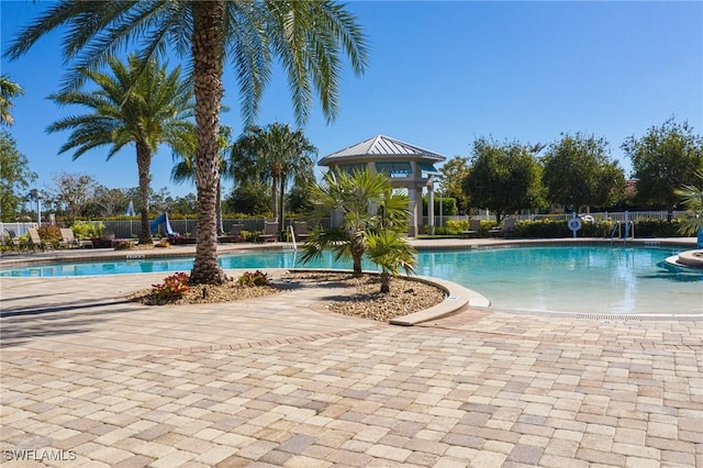 pool with a patio area and fence