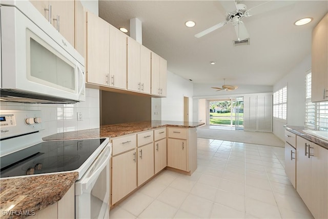 kitchen with tasteful backsplash, dark stone counters, ceiling fan, kitchen peninsula, and white appliances