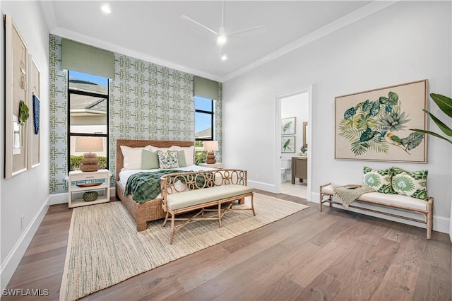 bedroom with crown molding, hardwood / wood-style floors, and ensuite bath