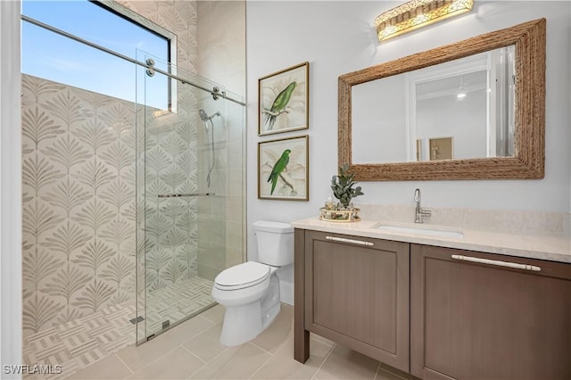 bathroom with an enclosed shower, vanity, tile patterned flooring, and toilet