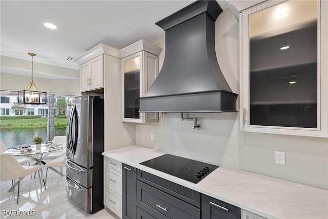 kitchen with premium range hood, pendant lighting, white cabinets, stainless steel fridge with ice dispenser, and black electric cooktop