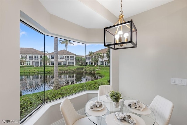 dining area with a water view and a chandelier