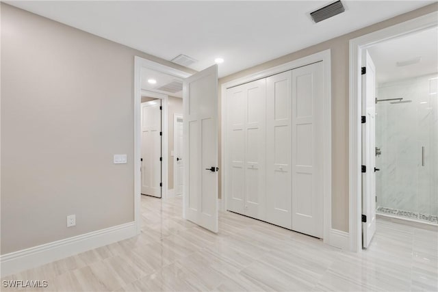 unfurnished bedroom featuring a closet and ensuite bathroom