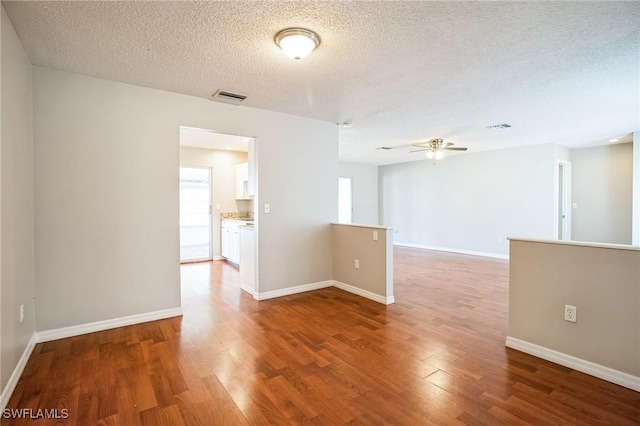 unfurnished room with hardwood / wood-style flooring, a textured ceiling, and ceiling fan