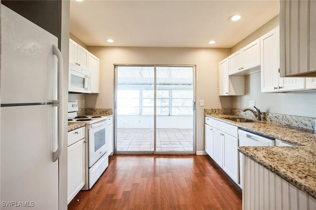 kitchen featuring sink, white appliances, light stone countertops, and white cabinets