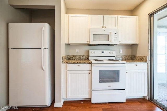 kitchen with hardwood / wood-style floors, white cabinetry, light stone counters, and white appliances