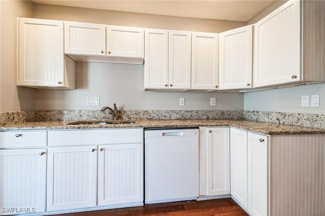 kitchen with white dishwasher, sink, and white cabinets