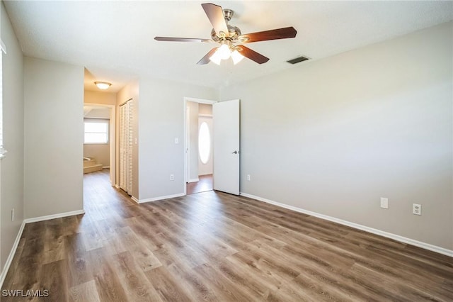 unfurnished bedroom with wood-type flooring, ceiling fan, and a closet