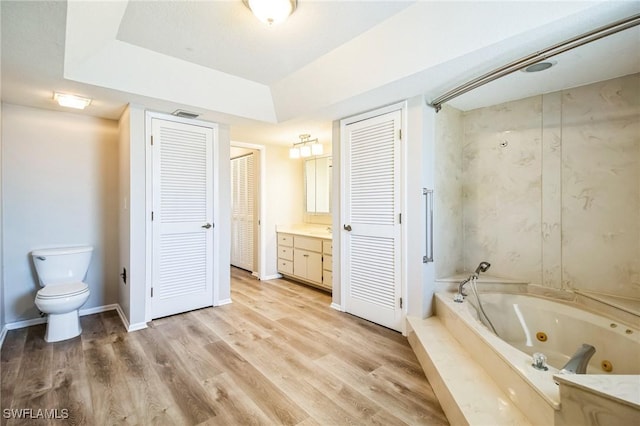 bathroom featuring hardwood / wood-style flooring, vanity, toilet, and a washtub