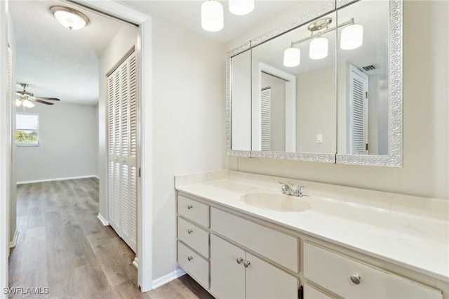 bathroom with vanity, hardwood / wood-style floors, and ceiling fan