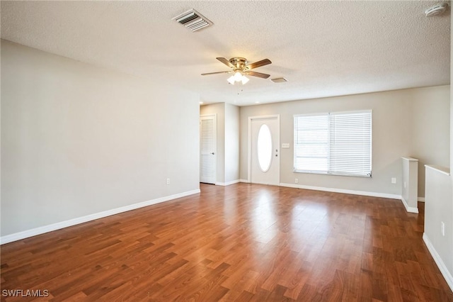 unfurnished living room with a textured ceiling, dark hardwood / wood-style floors, and ceiling fan