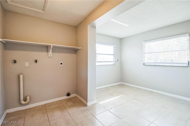 clothes washing area with gas dryer hookup, hookup for an electric dryer, and a textured ceiling