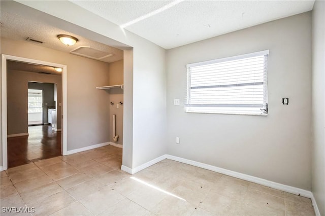 unfurnished bedroom featuring light tile patterned flooring and a textured ceiling