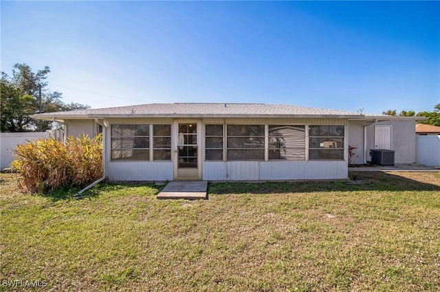 back of house with central AC, a sunroom, and a lawn