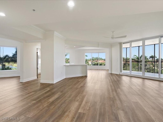 unfurnished living room featuring ornamental molding, hardwood / wood-style floors, and ceiling fan