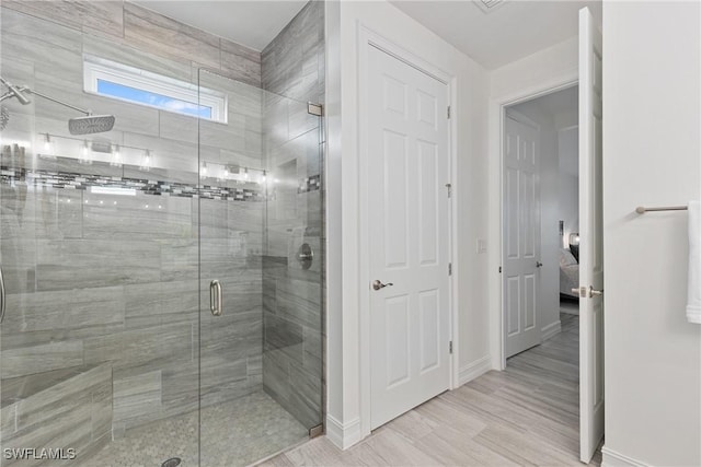 bathroom with hardwood / wood-style flooring and a shower with door