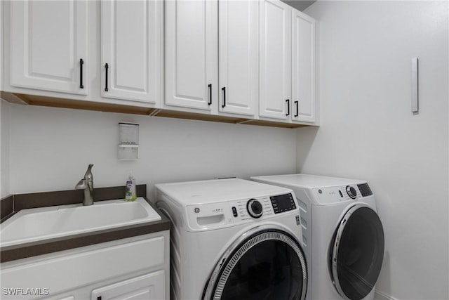 laundry area with washing machine and dryer, sink, and cabinets