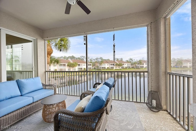 sunroom / solarium featuring a water view and ceiling fan