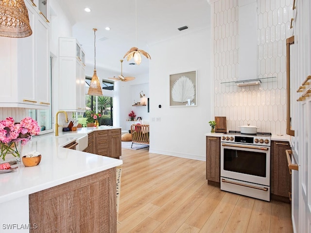 kitchen featuring sink, backsplash, white electric range oven, decorative light fixtures, and white cabinets