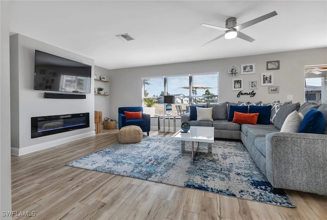 living room featuring wood-type flooring and ceiling fan